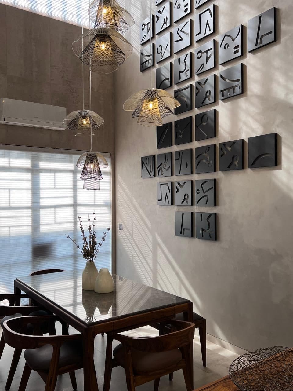 A Bungalow — Dining, against a wall of framed ceramic work